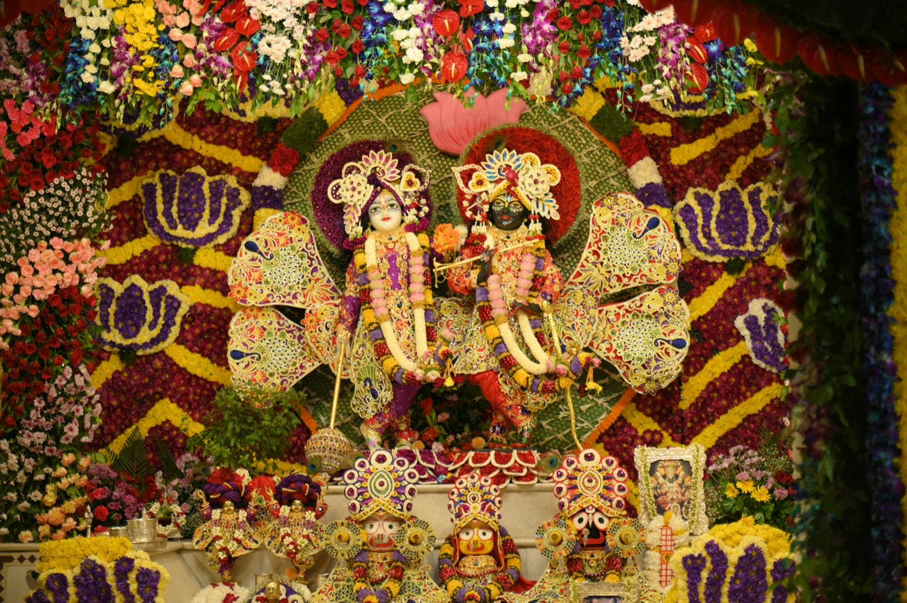 Radha and Krishna dressed and garlanded with fresh flowers for darshan
