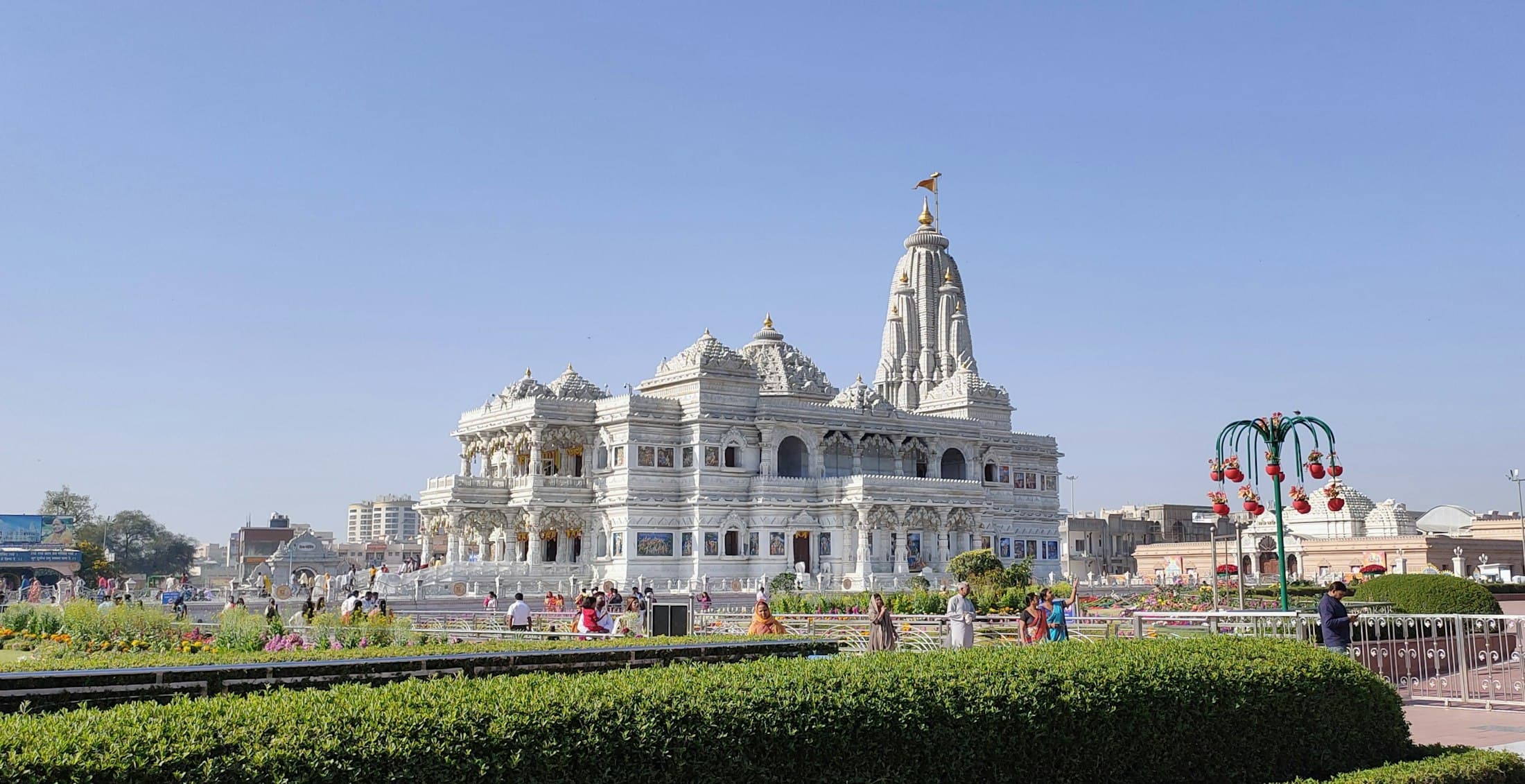 A white marble temple above formal gardens under a wide sky