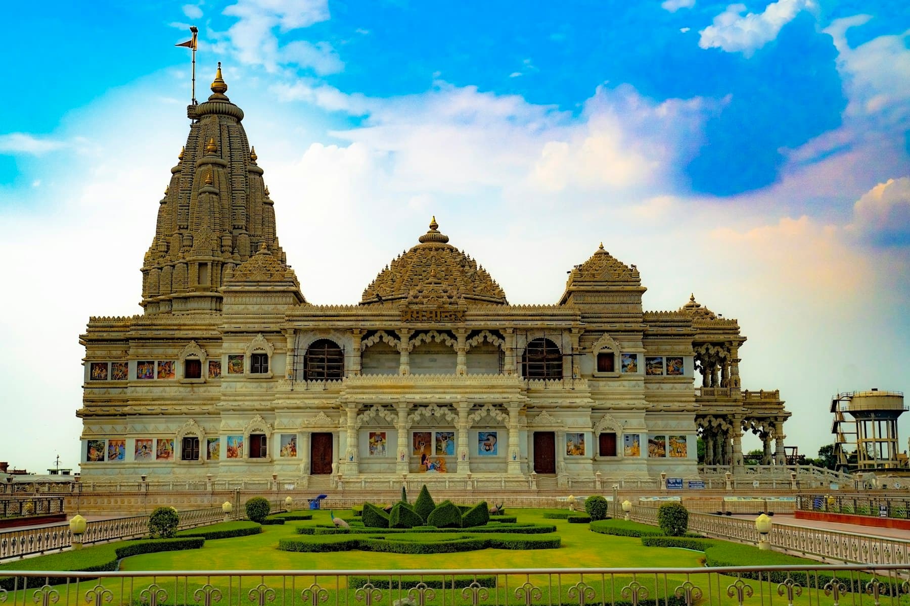 Prem Mandir in Vrindavan, its white marble lit against an evening sky
