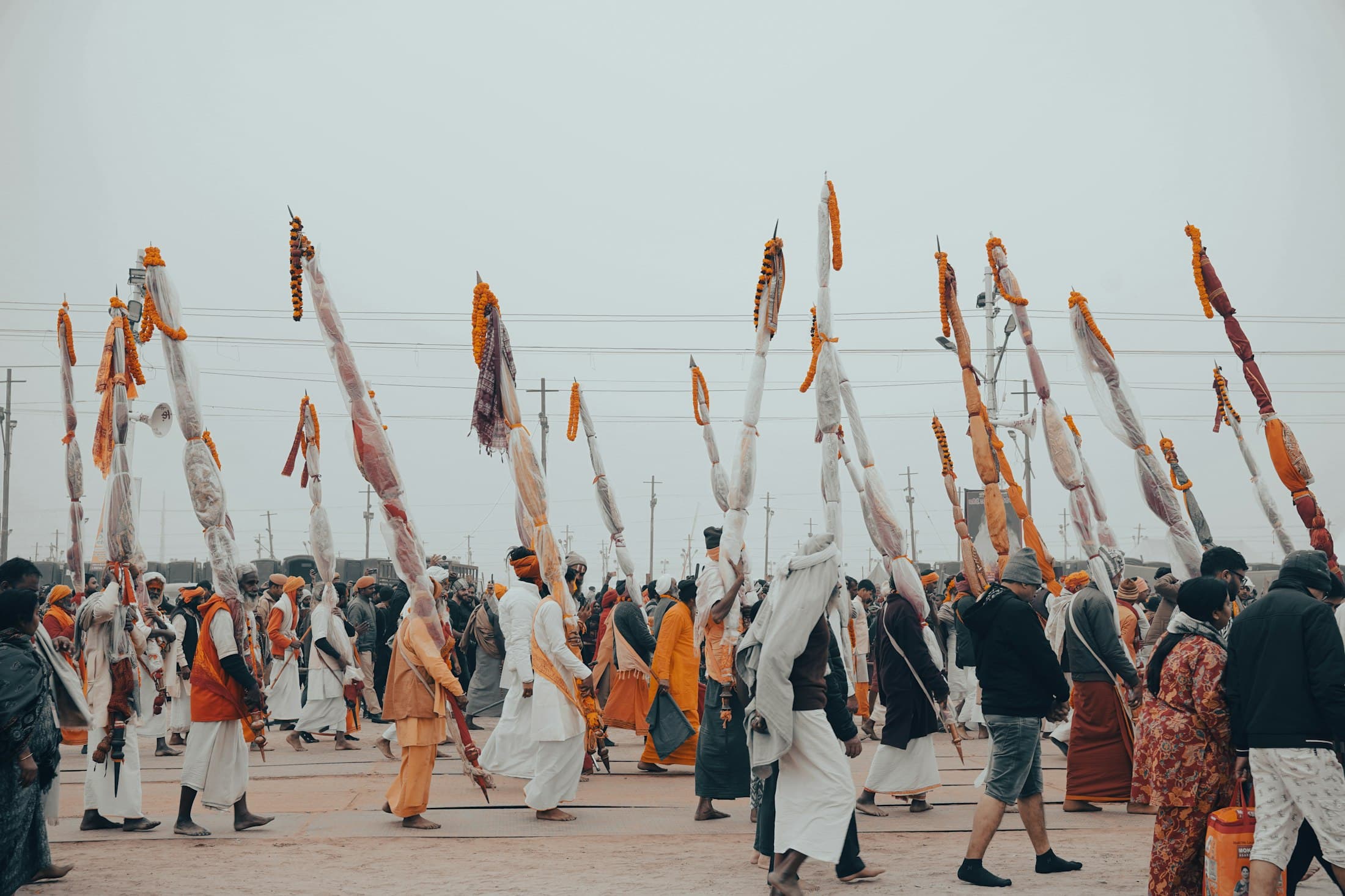 Pilgrims walking in procession beside the water, tall banners carried above them