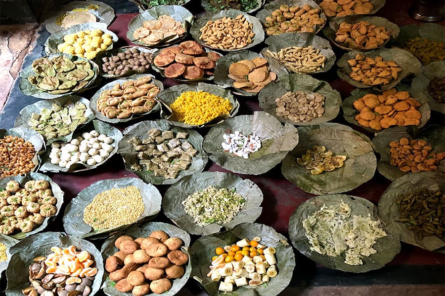 Rows of leaf plates laid out with dozens of separate preparations for the chhappan bhog